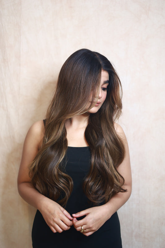 Model wearing SOPHIA 22-inch long wavy human hair wig with balayage, HD lace, glueless and clipless design, free parting, and breathable construction for all-day comfort; premium quality