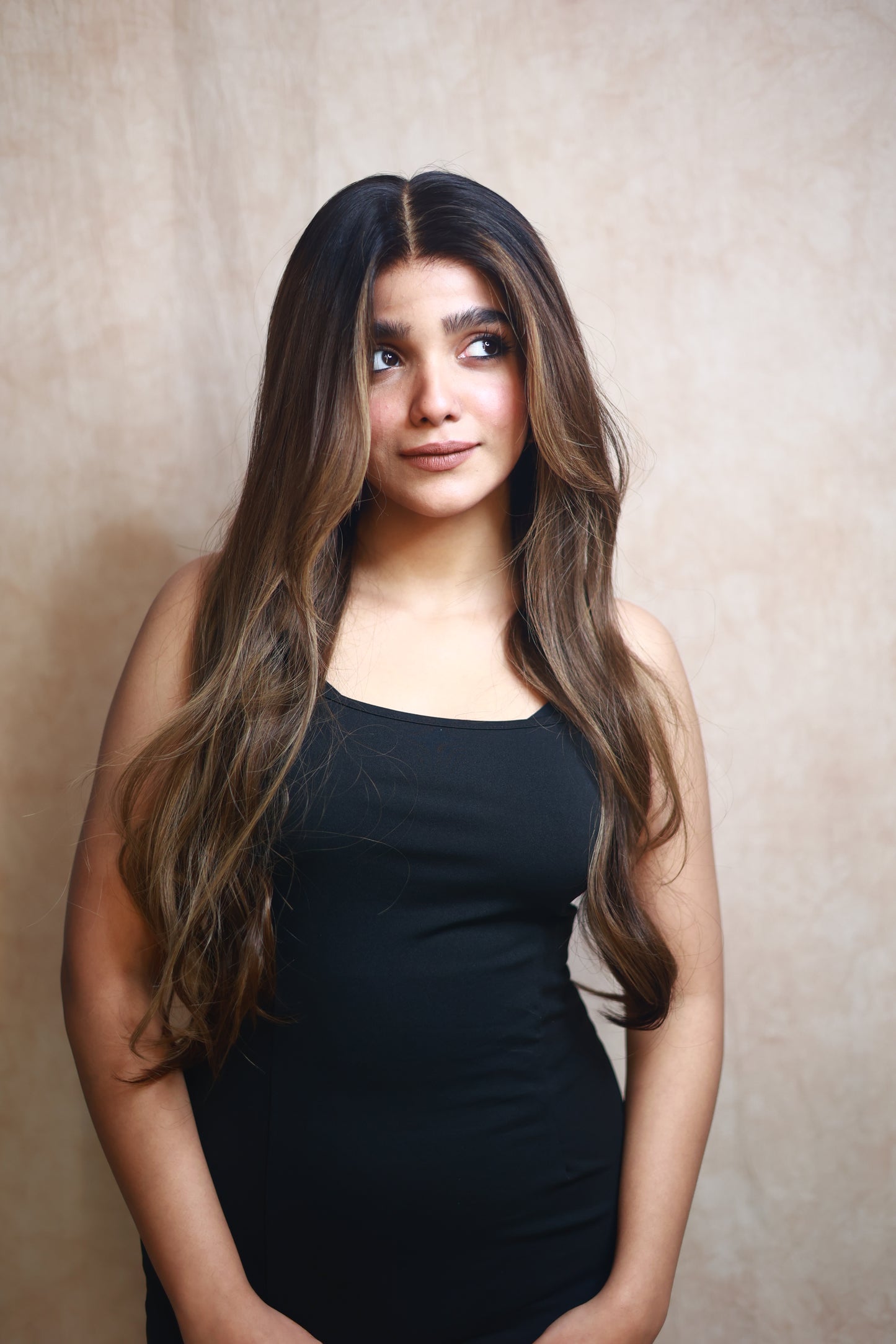 Model wearing SOPHIA 22-inch long wavy human hair wig with balayage, HD lace, glueless and clipless design, free parting, and breathable construction for all-day comfort; premium quality