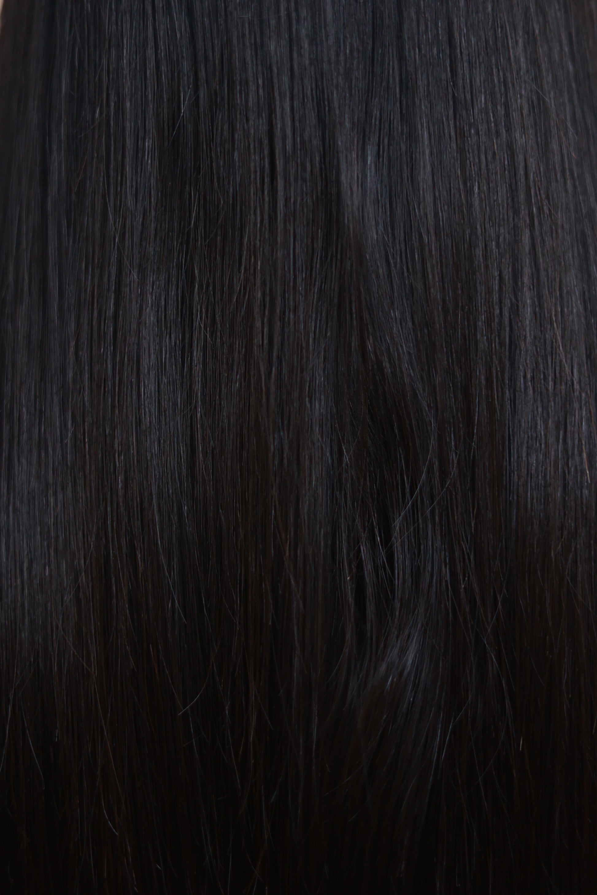 Model wearing GIGI 20-inch natural black wavy human hair wig with HD lace, glueless and clipless design, free parting, and breathable construction for all-day comfort